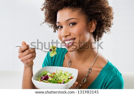stock-photo-close-up-of-beautiful-african-american-woman-eating-salad-at-home-131983145.jpg