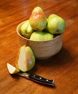 $Cut Pear with Pears in Wood Bowl.webp