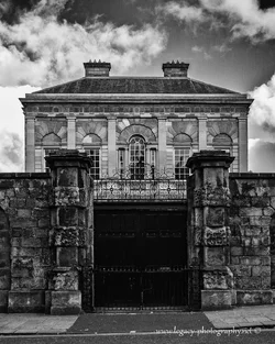 $Old building behind stone wall - BW.webp