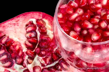 $Pomegranate and Glass of seeds on black.webp