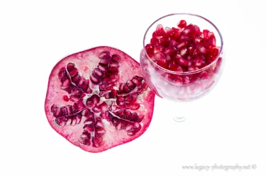 $Pomegranate and Glass of seeds on white - full - flash.webp