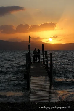 $Couple standing on a dock on the Kinneret at sunset.webp