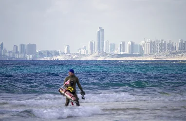 $Spear fisherman heading into ocean Tel Aviv in the background - small.webp $Spear fisherman heading into ocean Tel Aviv in the background - small.webp