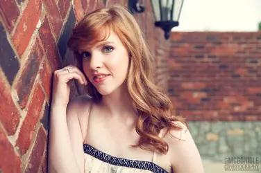 $girl-portrait-red-hair-brick.webp