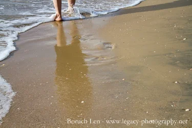 $reflection of legs in water beach waves.webp