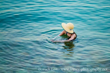 Woman in hat in Dead Sea - cropped to center of hands.webp