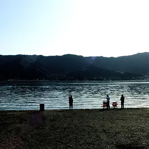Three Men Fishing On Lake Shore