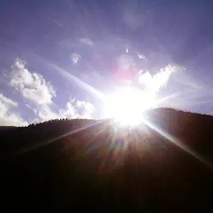 The sun smiles over mountains