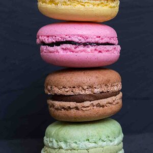 Colorful macarons on a black wood
