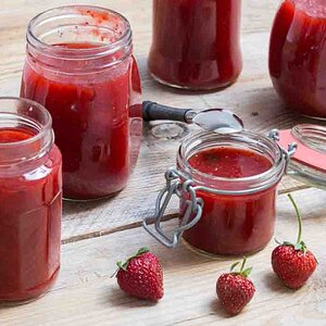 Strawberry jam in a jar on wood