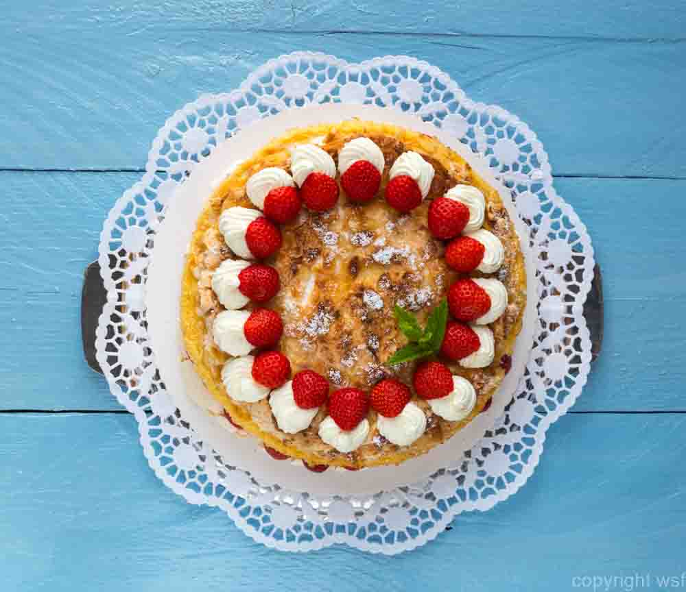 Meringue cake with strawberry yogurt on blue wood