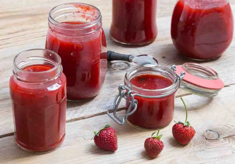 Strawberry jam in a jar on wood